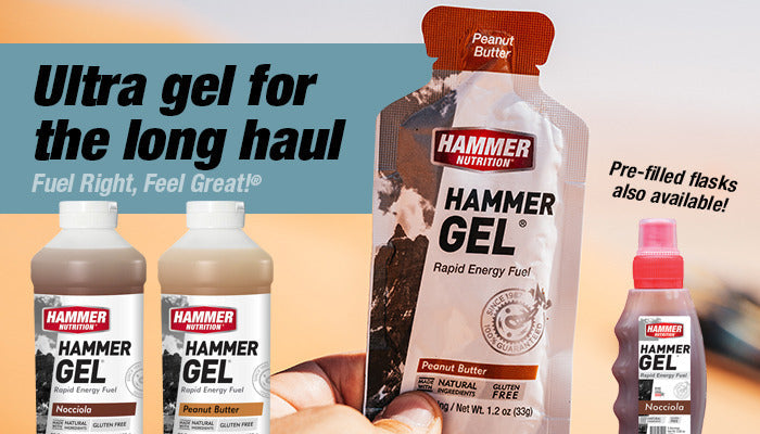 Hand holding Hammer Gel pack with sand in background.