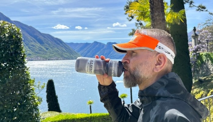Stefan Weiss drinking out of Hammer Water Bottle next to a lake