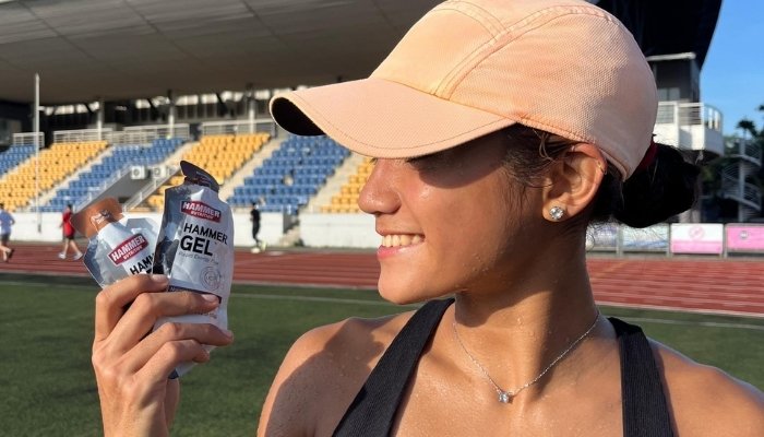 Esther Chen smiling while holding hammer gel at track