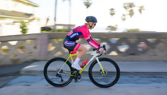 Hammer athlete cycling in Ruby kit